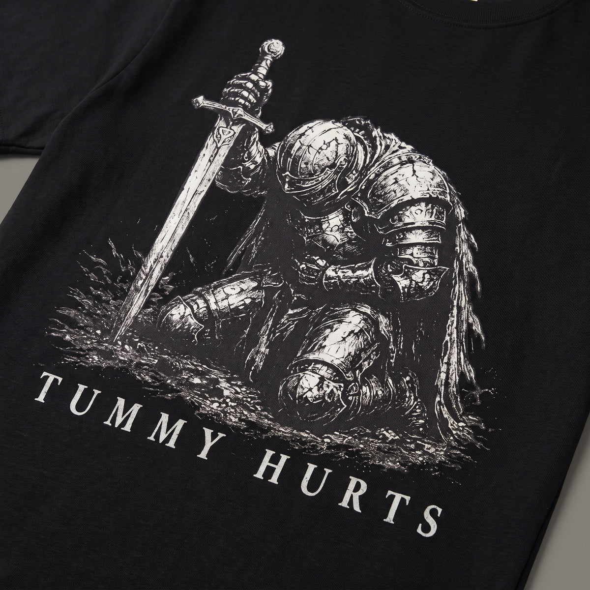 Detail view of kneeling knight artwork on black T-shirt